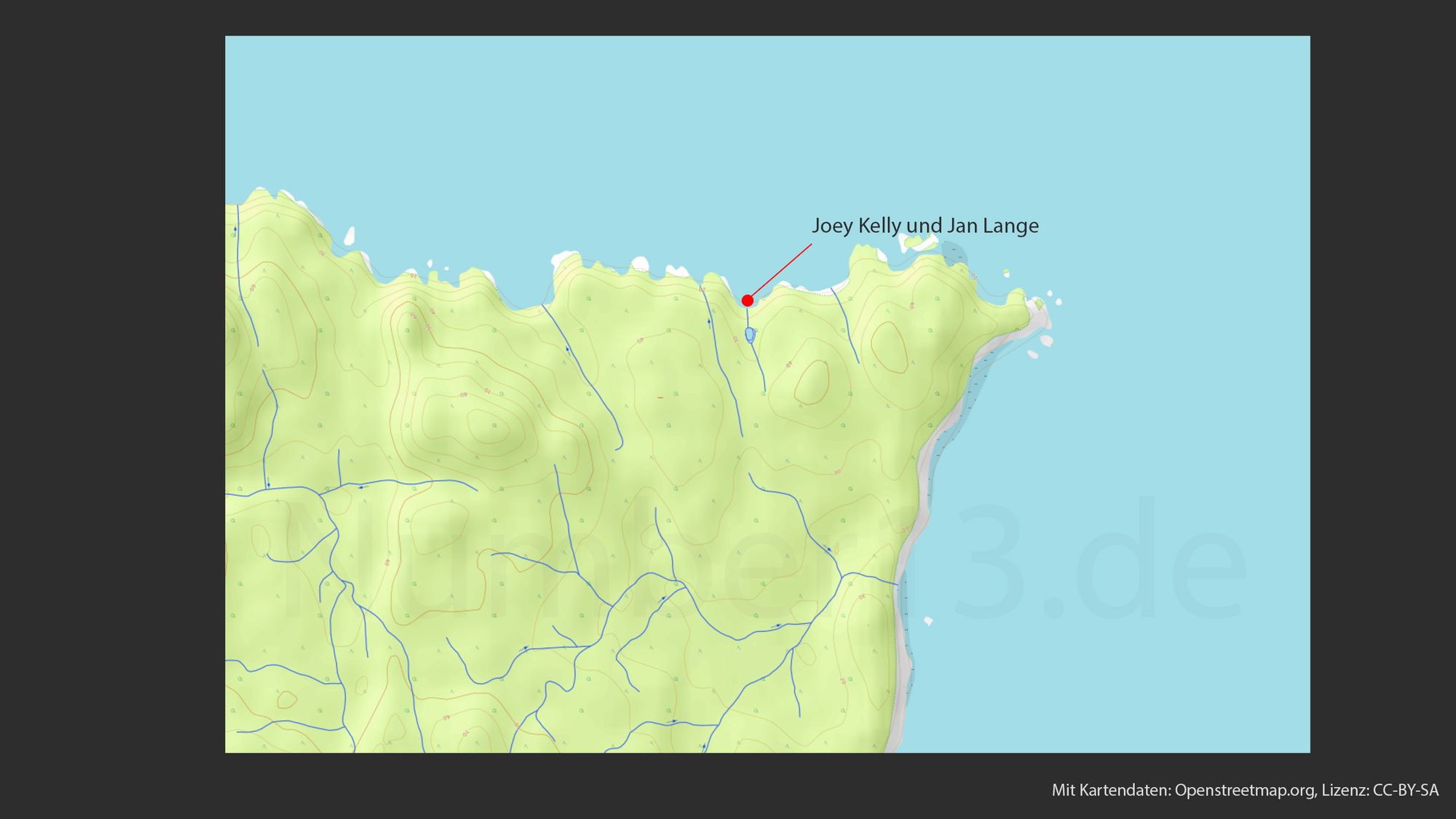 Topografische Karte, die eine hügelige Landschaft mit vielen Höhenlinien darstellt. Ein roter Punkt, markiert mit einem Pfeil, zeigt auf eine Stelle mit der Beschriftung "Joey Kelly und Jan Lange". Blaue Linien, die wahrscheinlich Flüsse oder Bäche darstellen, durchziehen die Karte. Der Umriss einer Küstenlinie ist an der rechten Seite sichtbar. Die Karte trägt die Beschriftung "Mit Kartendaten: Openstreetmap.org, Lizenz: CC-BY-SA" am unteren Rand.