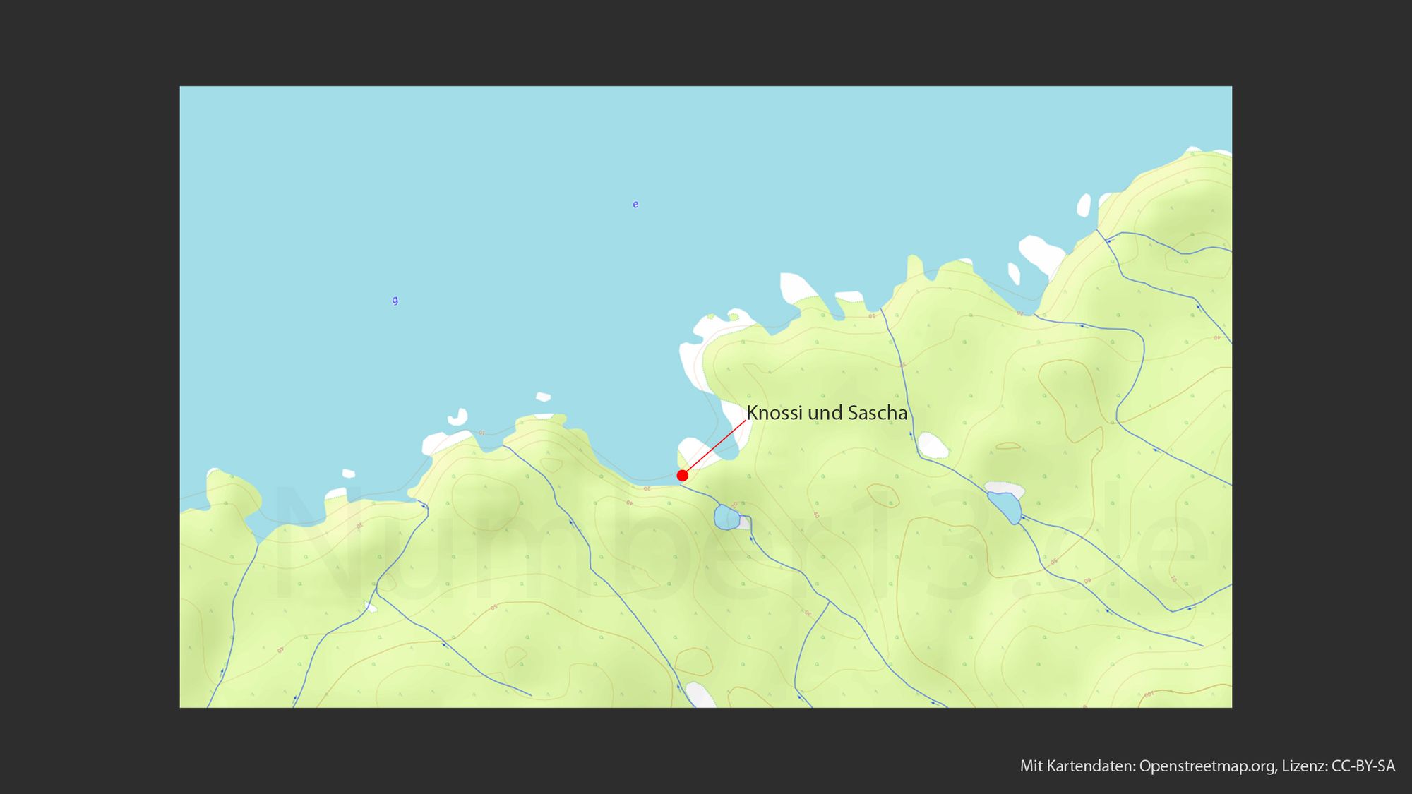 Karte, die einen Ausschnitt eines Geländes mit topographischen Linien anzeigt. Ein roter Punkt mit einem beschrifteten Pfeil deutet auf einen Ort namens "Knossi und Sascha". Die umgebende Landschaft zeigt Höhenlinien, was auf hügeliges Terrain hindeutet, sowie einige kleine Gewässer. Im Hintergrund ist ein großer blauer Bereich, der wahrscheinlich Wasser darstellt. Die Legende besagt "Mit Kartendaten: Openstreetmap.org, Lizenz: CC-BY-SA